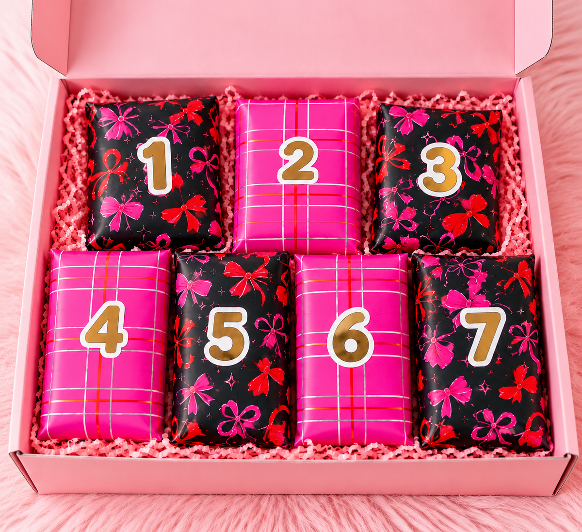 7-daagse adventskalender in een roze cadeaudoos met zeven genummerde cadeautjes in zwart-roze strikjespapier en felroze ruitjespapier.
