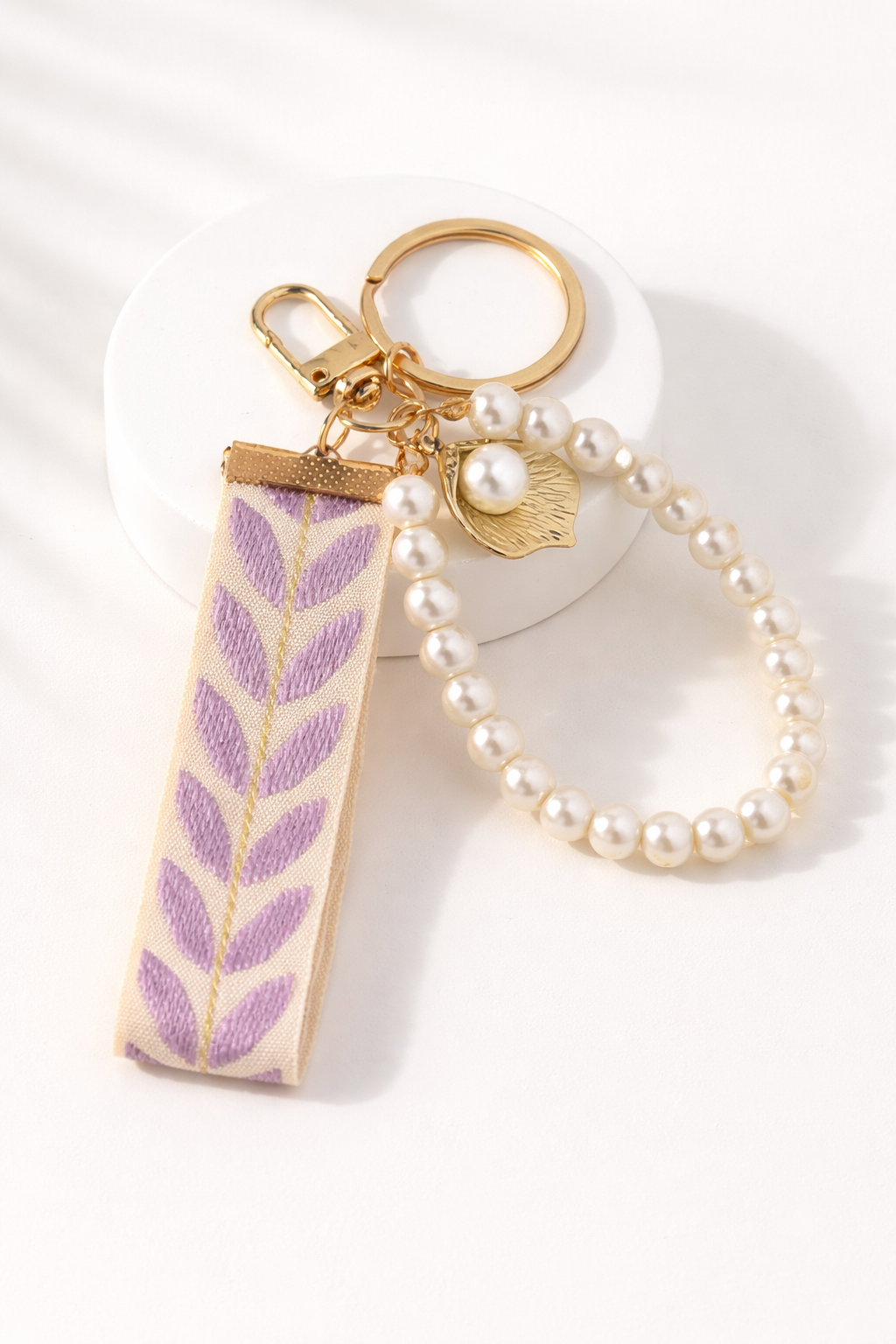 Paarse parel sleutelhanger met glanzende afwerking, elegante en stijlvolle accessoire voor tas of sleutelbos.