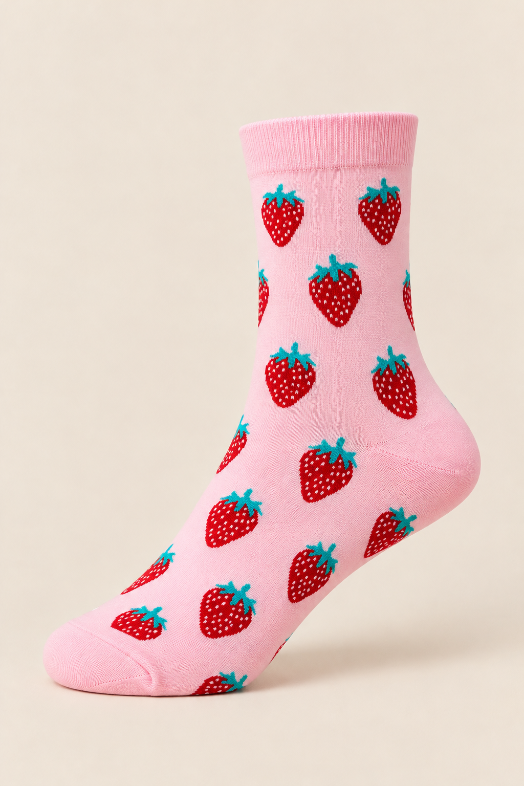 Roze damessok met rode aardbeienprint en groene blaadjes op een beige achtergrond.
