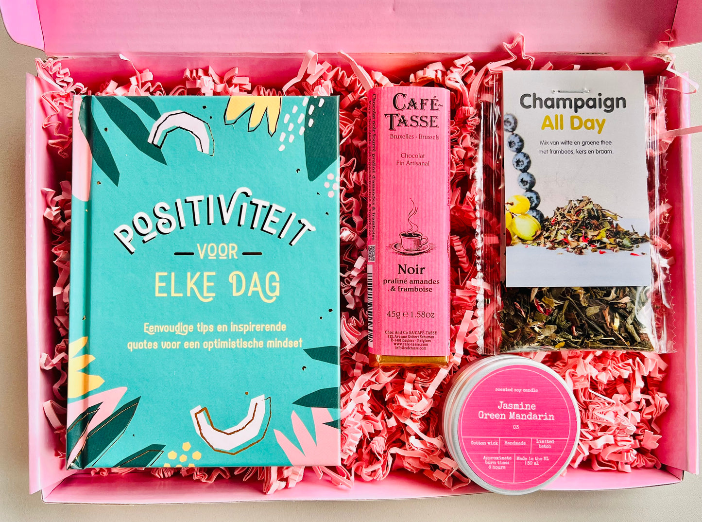 Brievenbus cadeaubox positiviteit met boekje positiviteit voor elke dag, champagne thee, geurkaars en chocolade praline framboos
