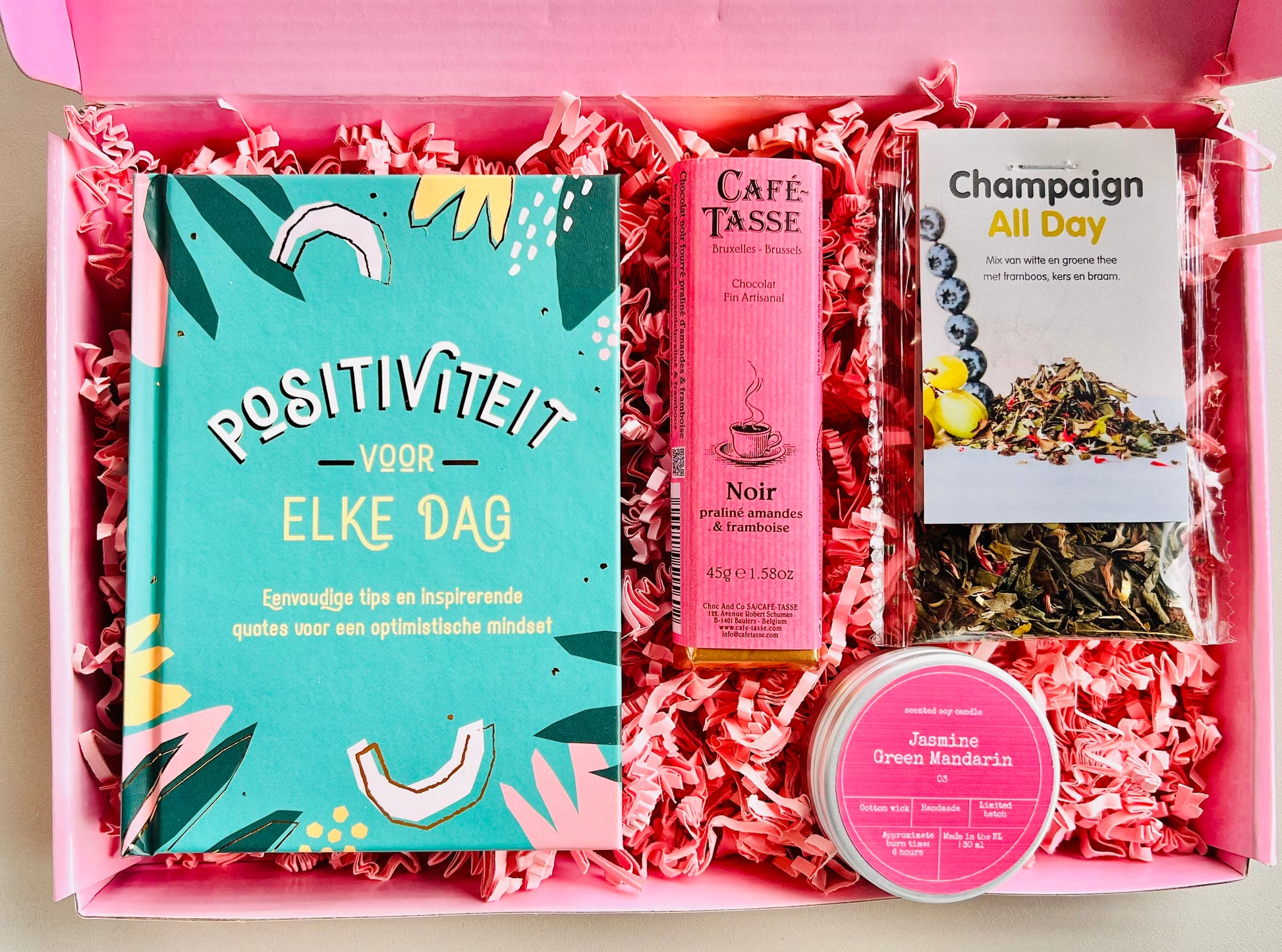 Brievenbus cadeaubox positiviteit met boekje positiviteit voor elke dag, champagne thee, geurkaars en chocolade praline framboos
