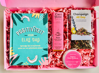 Brievenbus cadeaubox positiviteit met boekje positiviteit voor elke dag, champagne thee, geurkaars en chocolade praline framboos
