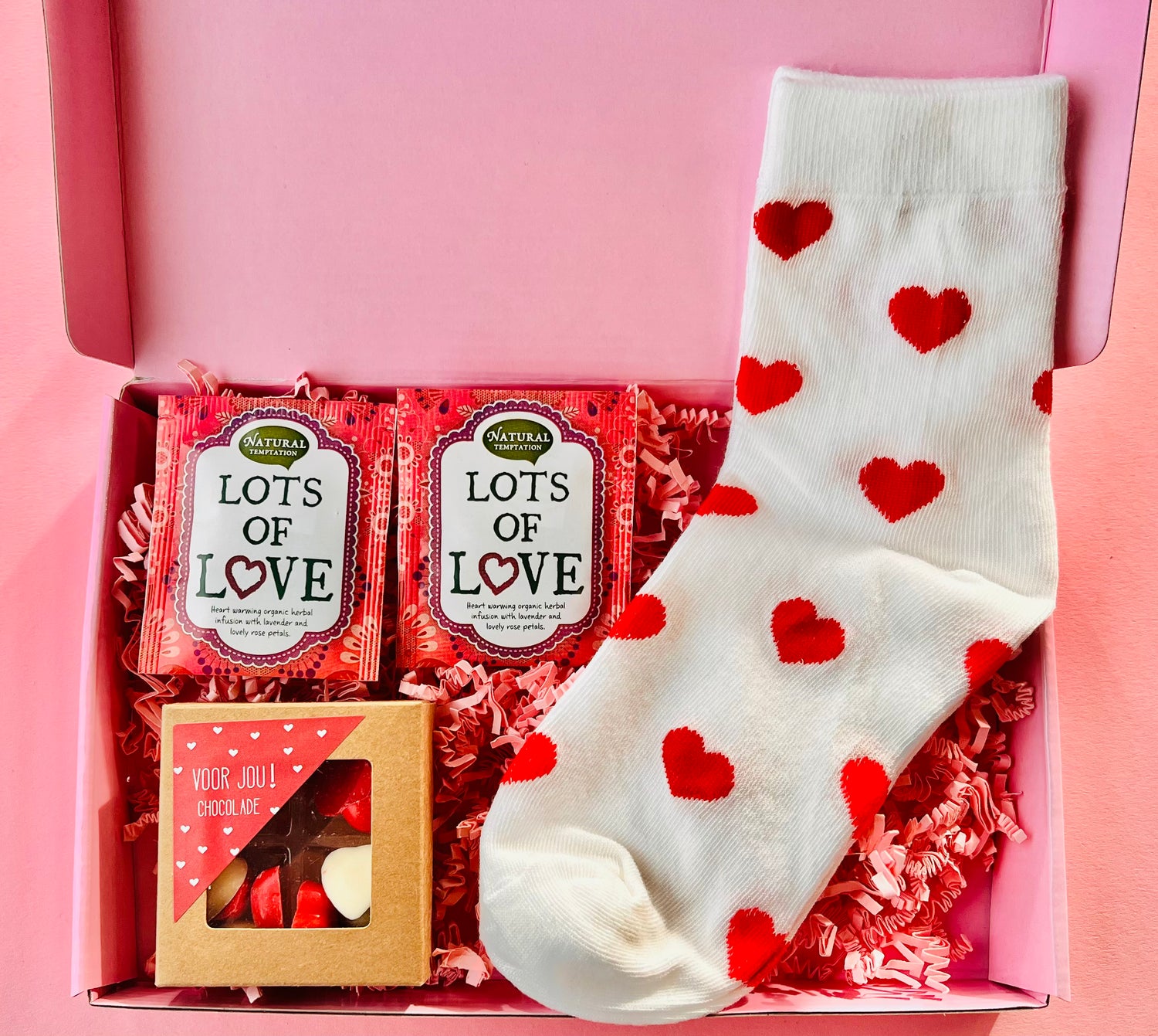 Brievenbus cadeau met hartjes sokken, thee en chocolade feestelijk verpakt