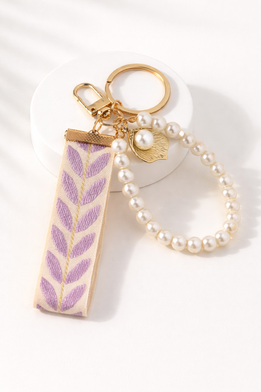 Paarse parel sleutelhanger met glanzende afwerking, elegante en stijlvolle accessoire voor tas of sleutelbos.