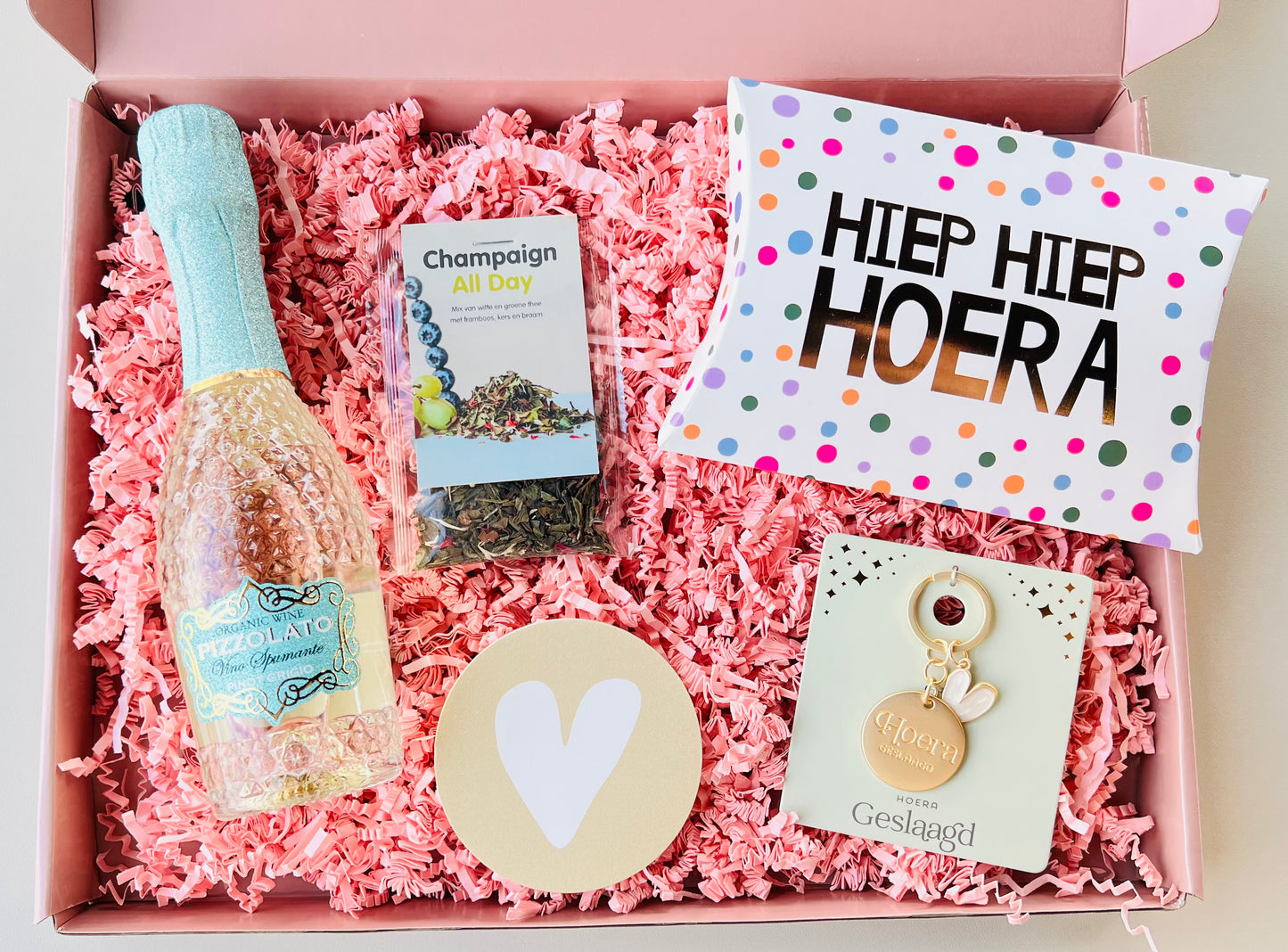 Luxe Geslaagd Cadeaubox met mini Pizzolato Pinot Grigio, mini champagne, thee, Hoera Geslaagd sleutelhanger, gondeldoosje met toffees, forex onderzetter met hartje en persoonlijke cadeaukaart, feestelijk verpakt als origineel diploma cadeau.