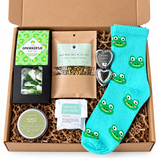 Kraft cadeaubox met turquoise sokken met kikkerprint, kikkersnoepjes, beterschapsthee, hartvormig theezeefje, eucalyptus shower steamer en bergamot zeezout