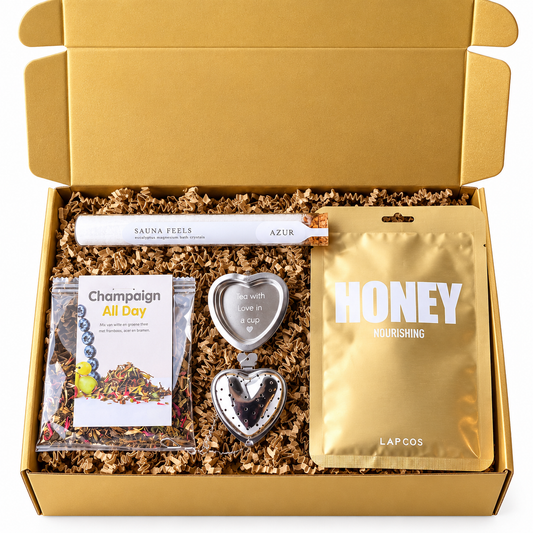 Luxe gouden verwen-cadeaubox met Champaign All Day thee, Sauna Feels eucalyptus badkristallen, hartvormige theezeef en Honey Nourishing gezichtsmasker van LAPCOS.