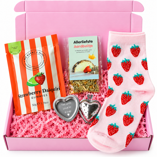 Roze cadeaubox met roze sokken met aardbeienprint, Strawberry Daiquiri gummies, aardbeienthee en twee hartvormige theeaccessoires.