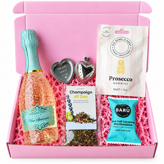 Roze cadeaubox met Pizzolato rosé mousserende wijn, Prosecco gummies, Champagne All Day thee, BARÚ zeezout-karamelmarshmallow met pure chocolade en hartvormige theeaccessoires.