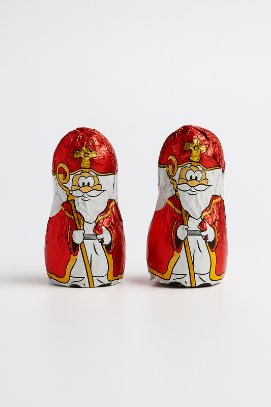 Twee Sinterklaas chocoladefiguren in feestelijke rode Sinterklaasverpakking op witte achtergrond